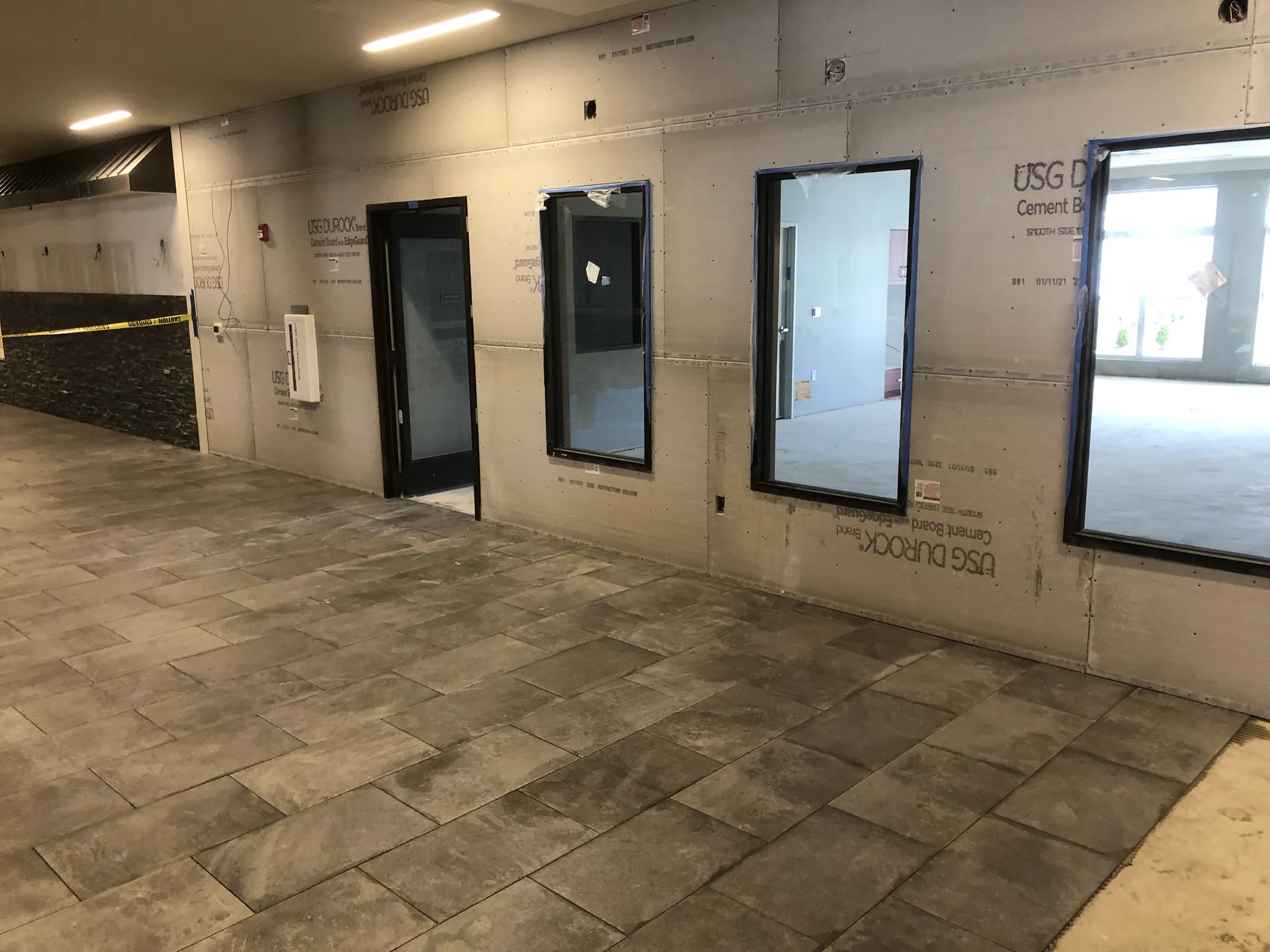 Commercial floor tile installation with large-format grey porcelain tiles